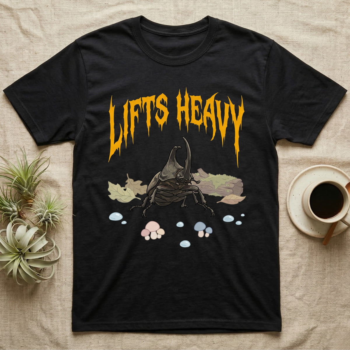 Rhino Beetle Feral T-Shirt in Black — Horned rhinoceros beetle standing head-on below a dripping amber-gold metal "Lifts Heavy" wordmark