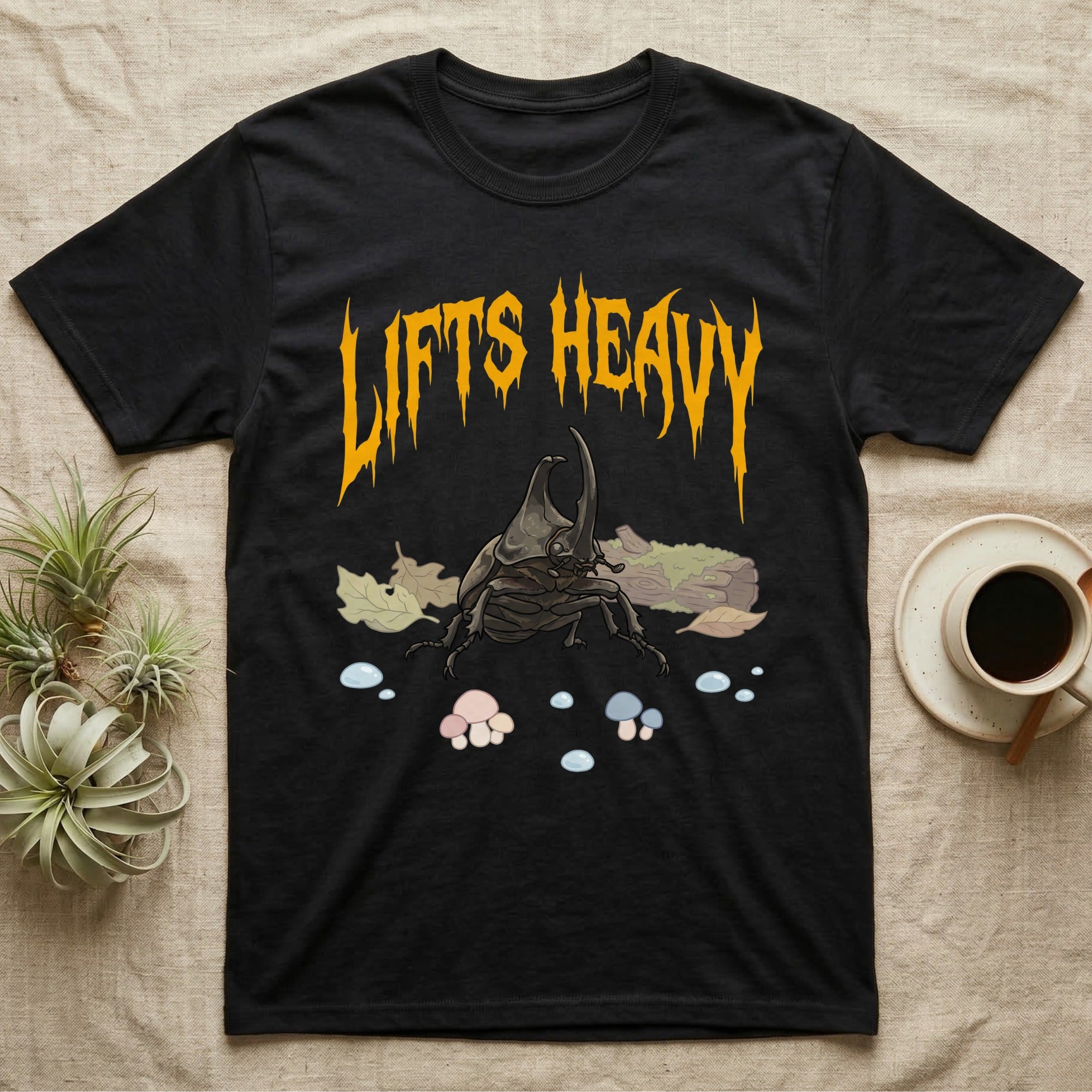 Rhino Beetle Feral T-Shirt in Black — Horned rhinoceros beetle standing head-on below a dripping amber-gold metal "Lifts Heavy" wordmark