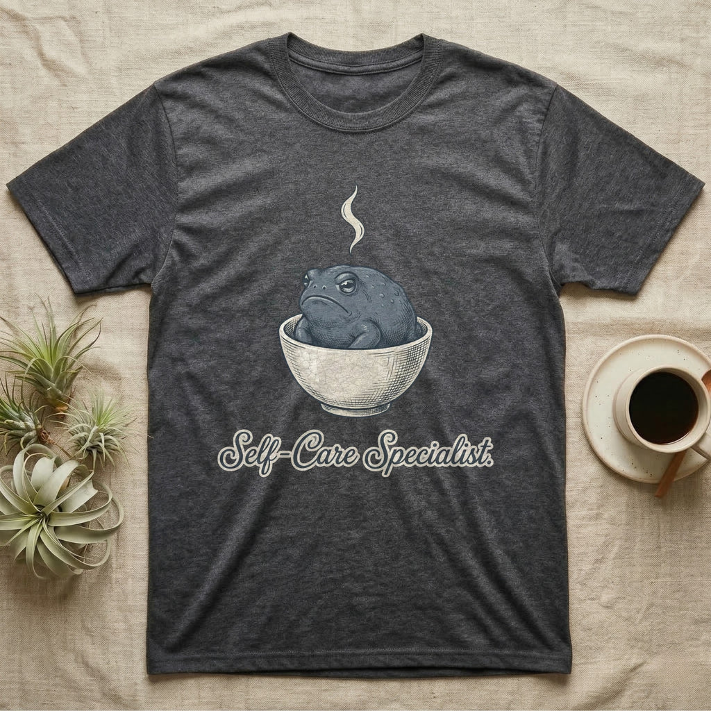 Dark gray t-shirt with a cartoon toad in a bowl and "Self-Care Specialist" text.