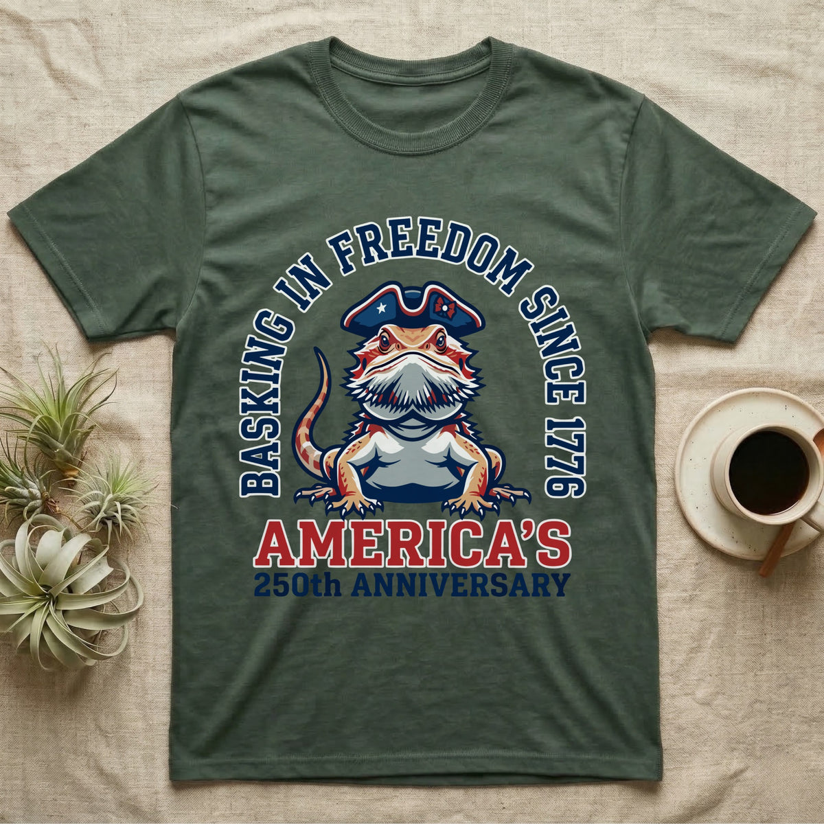 Bearded Dragon Basking T-Shirt in Military Green — Sports-logo bearded dragon in a tricorn hat under a collegiate arch reading Basking in Freedom Since 1776.