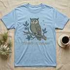 Light blue t-shirt with a stylized owl on a branch and the text "Stillness is not laziness."