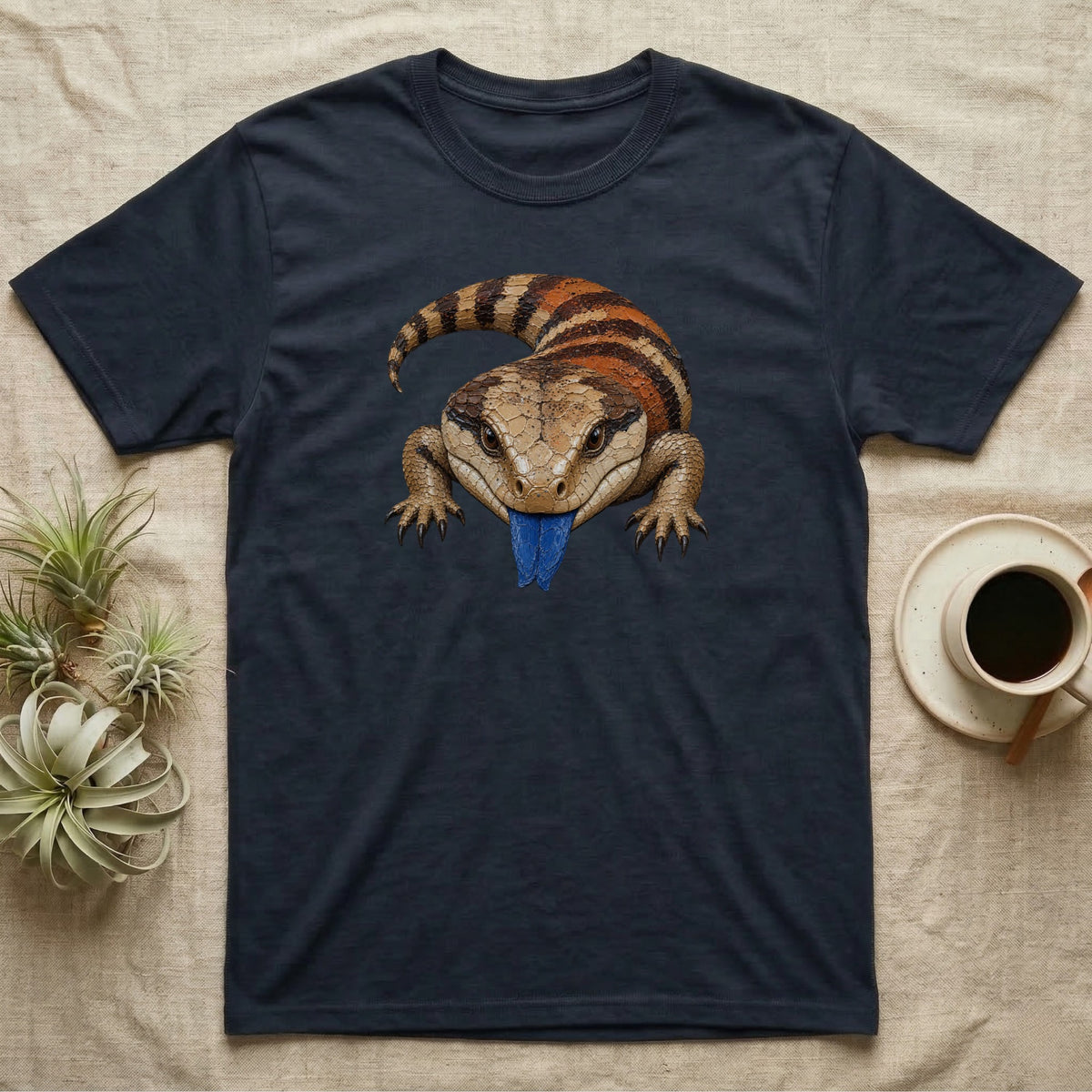 Blue-tongued skink with bright blue tongue sticking out on a dark t-shirt.