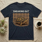 Box Turtle Sneaking T-Shirt in Navy — Eastern box turtle crawling out from under a brown picket fence beneath the words Sneaking Out