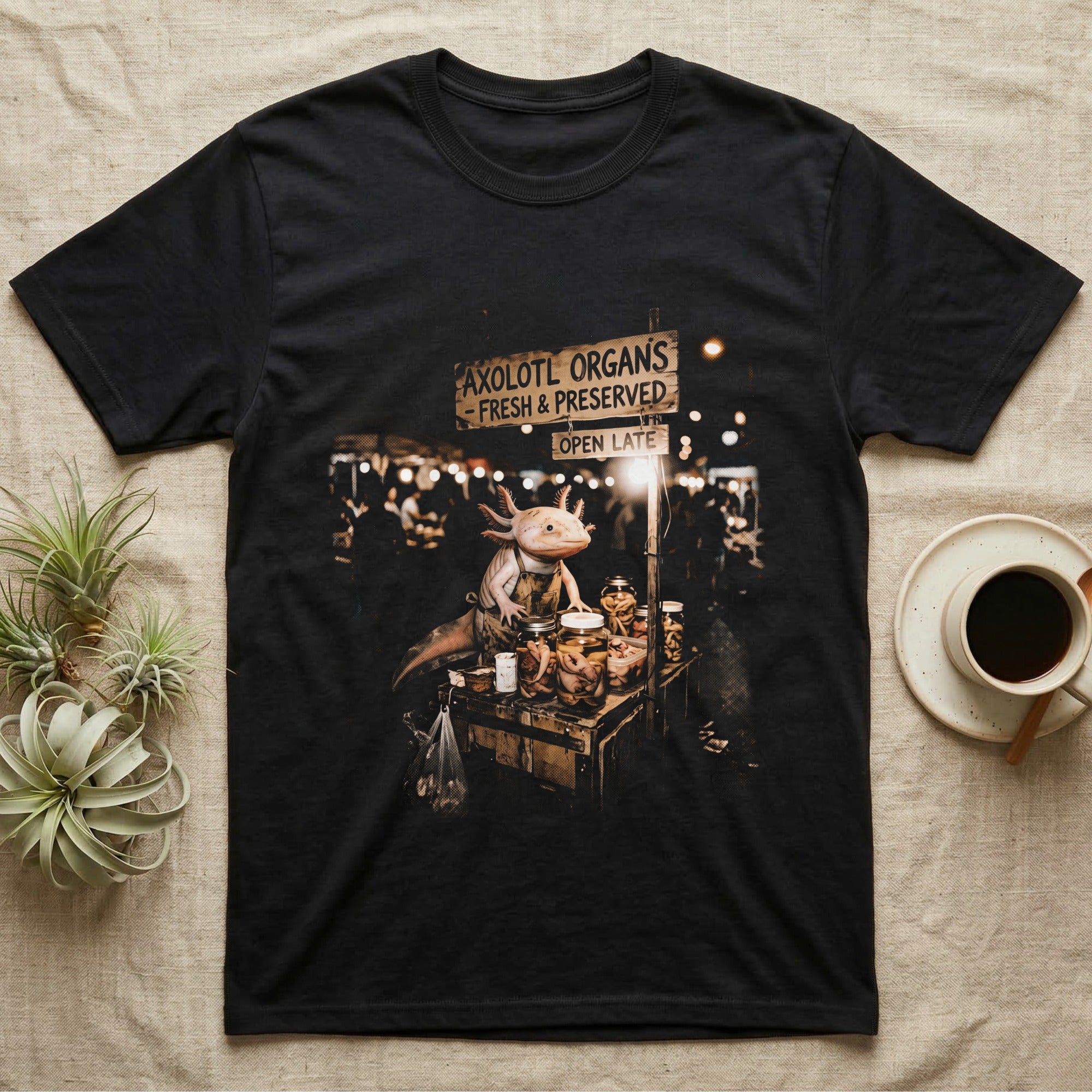 Axolotl Night Market T-Shirt in Black — Pink axolotl in an apron running a night-market stall under an "Axolotl Organs" sign in vintage halftone.