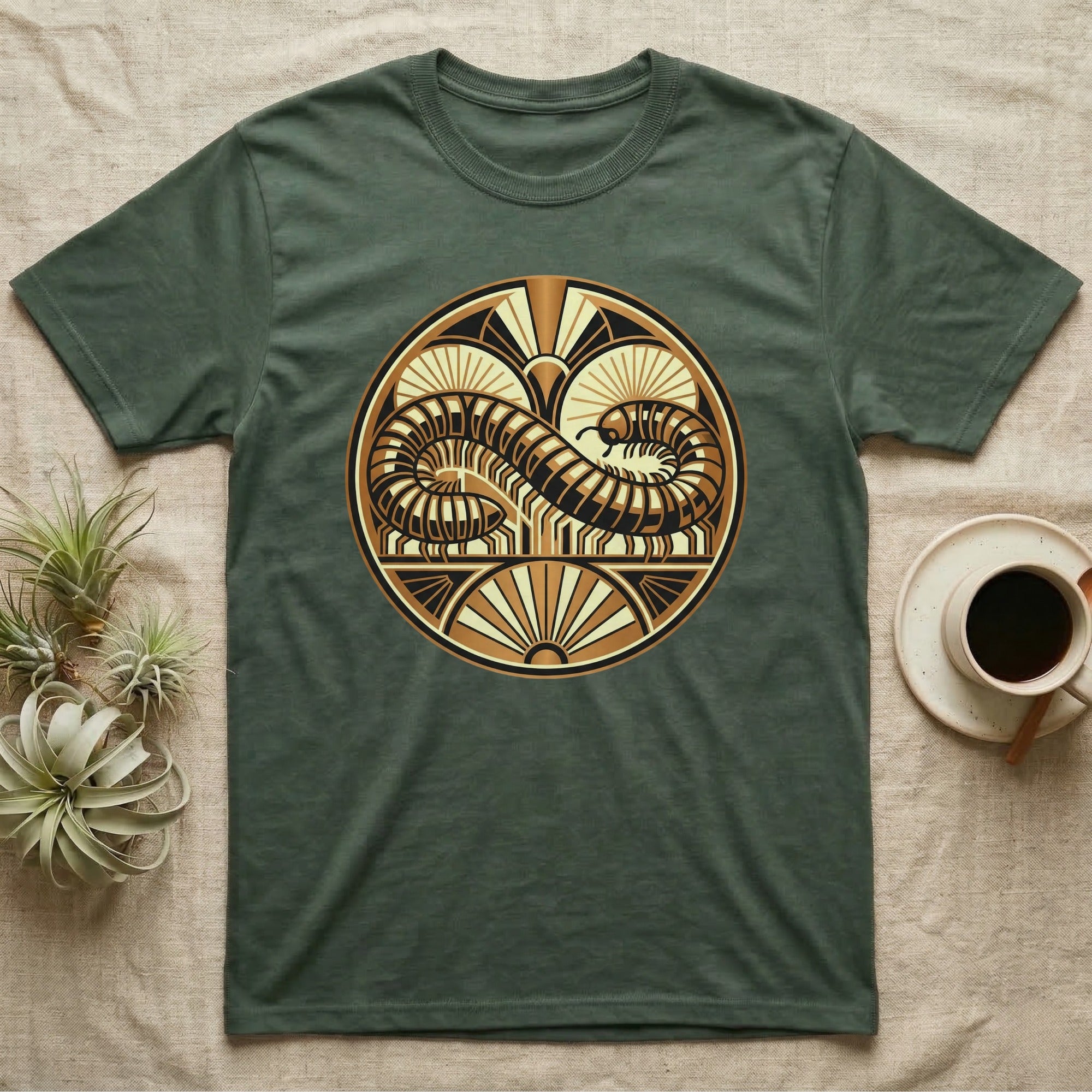 Green t-shirt with a circular gold and black art deco-style worm design.