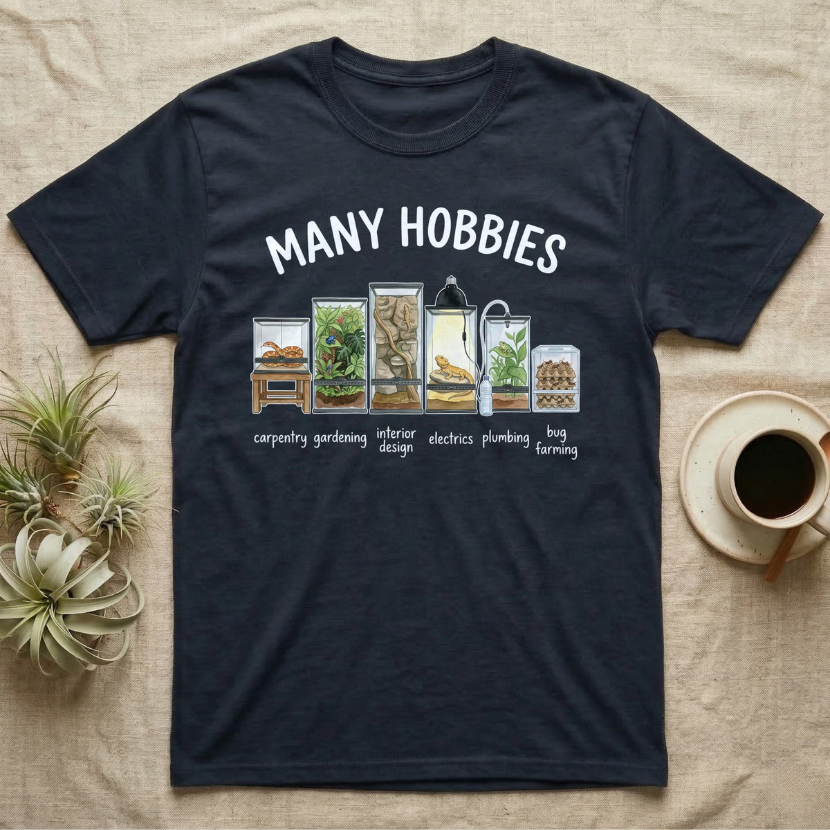 Reptile Terrarium Hobbies T-Shirt in Navy — Watercolour row of reptile vivariums with a snake, dart frog, gecko, bearded dragon, tree frog and a cricket bin under MANY HOBBIES, each labelled carpentry to bug farming