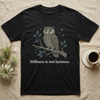 Black t-shirt with owl on branch and text "Stillness is not laziness."