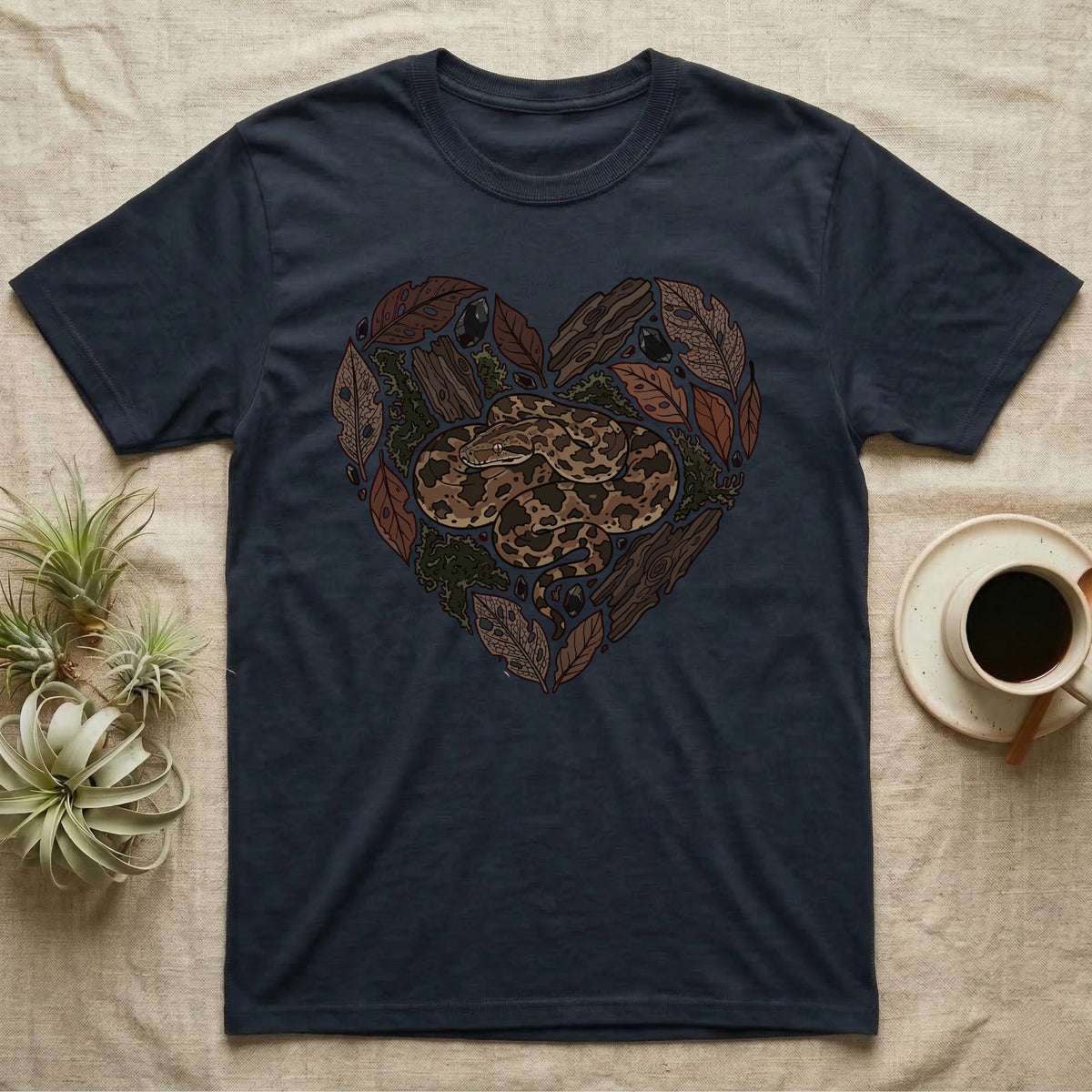 Dark t-shirt with a heart-shaped design of a snake and natural elements.