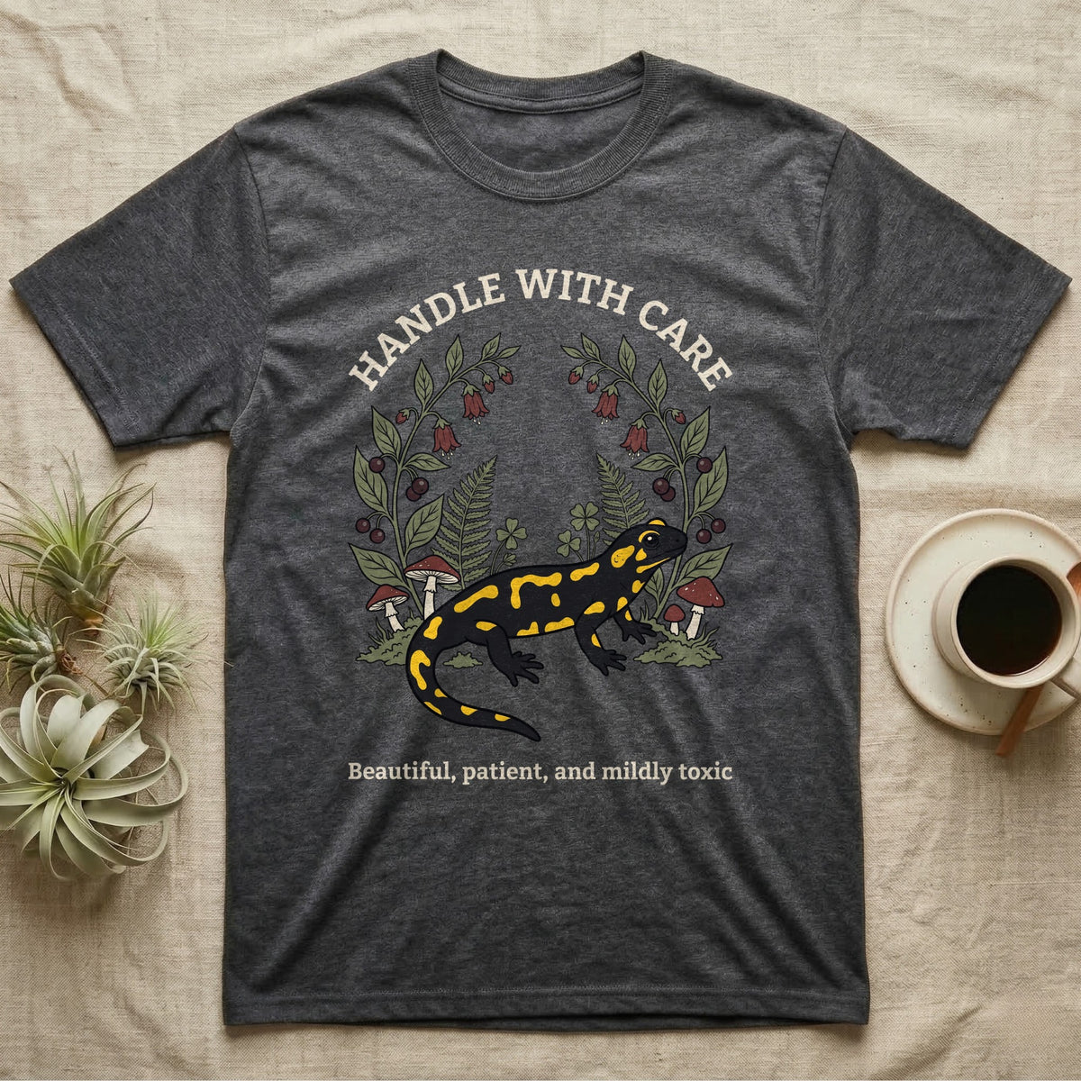 Fire Salamander Poison Plate T-Shirt in Dark Heather — Naturalist apothecary-plate illustration of a fire salamander framed by a symmetric wreath of woodland botanicals.