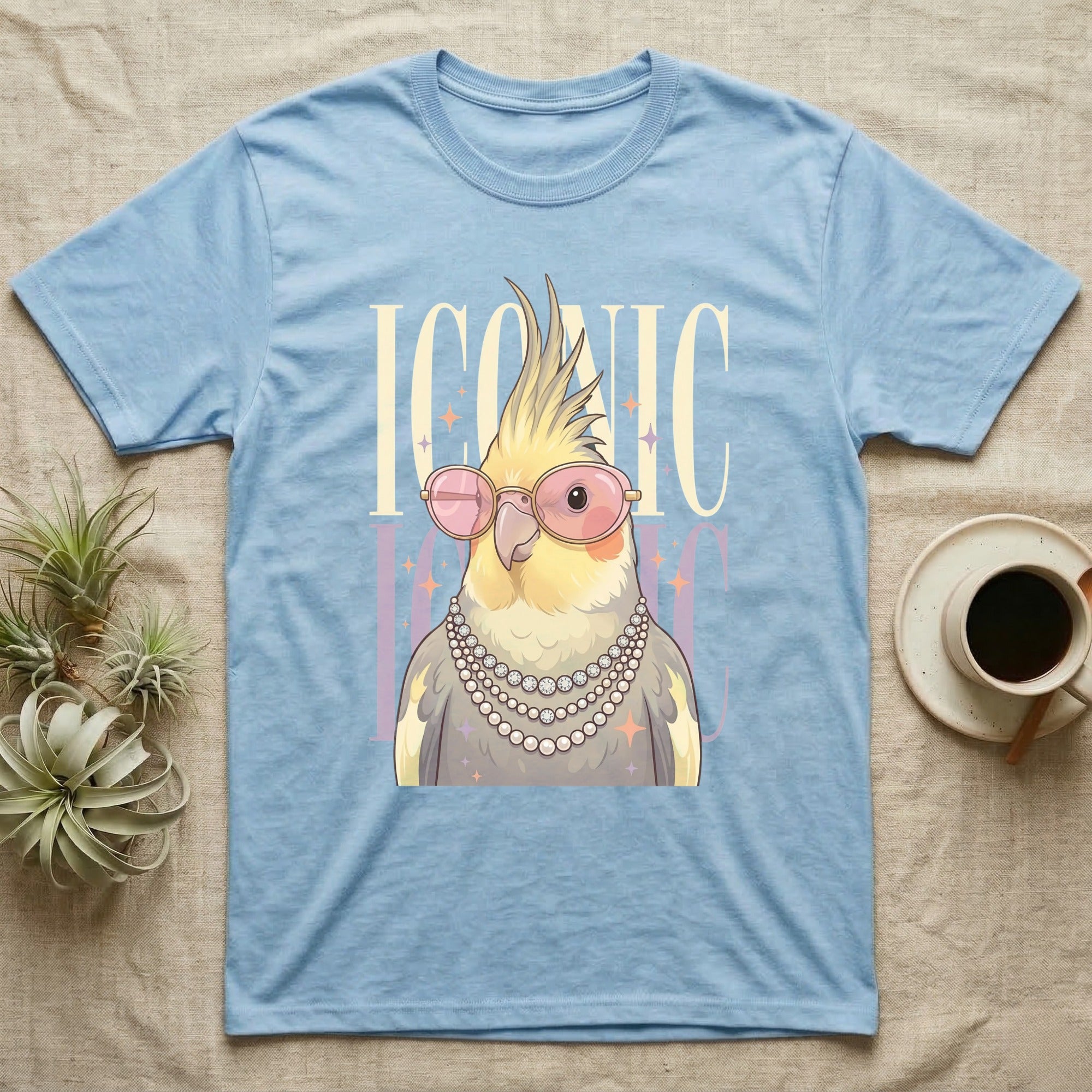 Blue t-shirt featuring a cockatiel wearing sunglasses and pearls, with "ICONIC" text.
