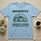 Snapping Turtle Rock T-Shirt in Light Blue — Engraved snapping turtle hunkered like a mossy rock, facing forward, with the words Honestly, Mostly a Rock, Occasionally I Bite