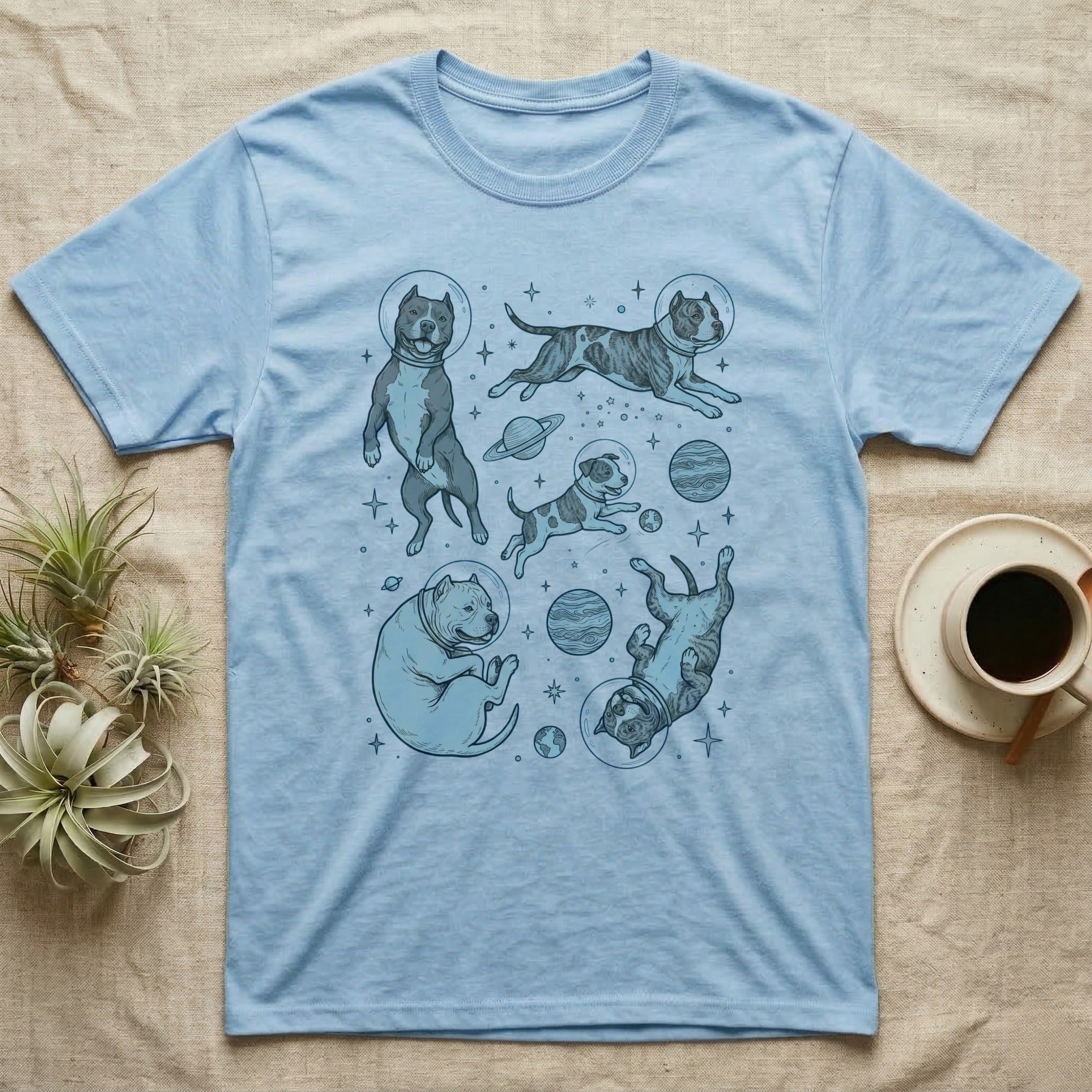 Light blue t-shirt with line drawings of dogs in space.