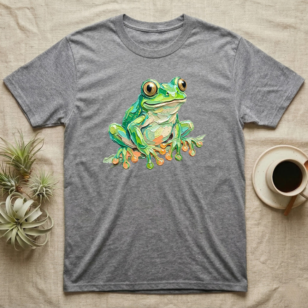 Grey t-shirt with a colorful cartoon frog illustration.