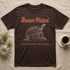 Red-Foot Tortoise Armor T-Shirt in Dark Chocolate — White-line engraving of a red-footed tortoise on tiptoe under orange Armor-Plated script and a serif line