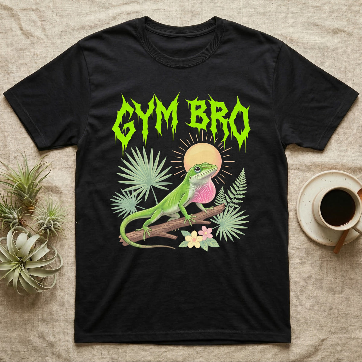 Green Anole Feral T-Shirt in Black — Green anole mid push-up with flared pink dewlap under a jagged neon-lime metal "GYM BRO" wordmark and pastel ferns.