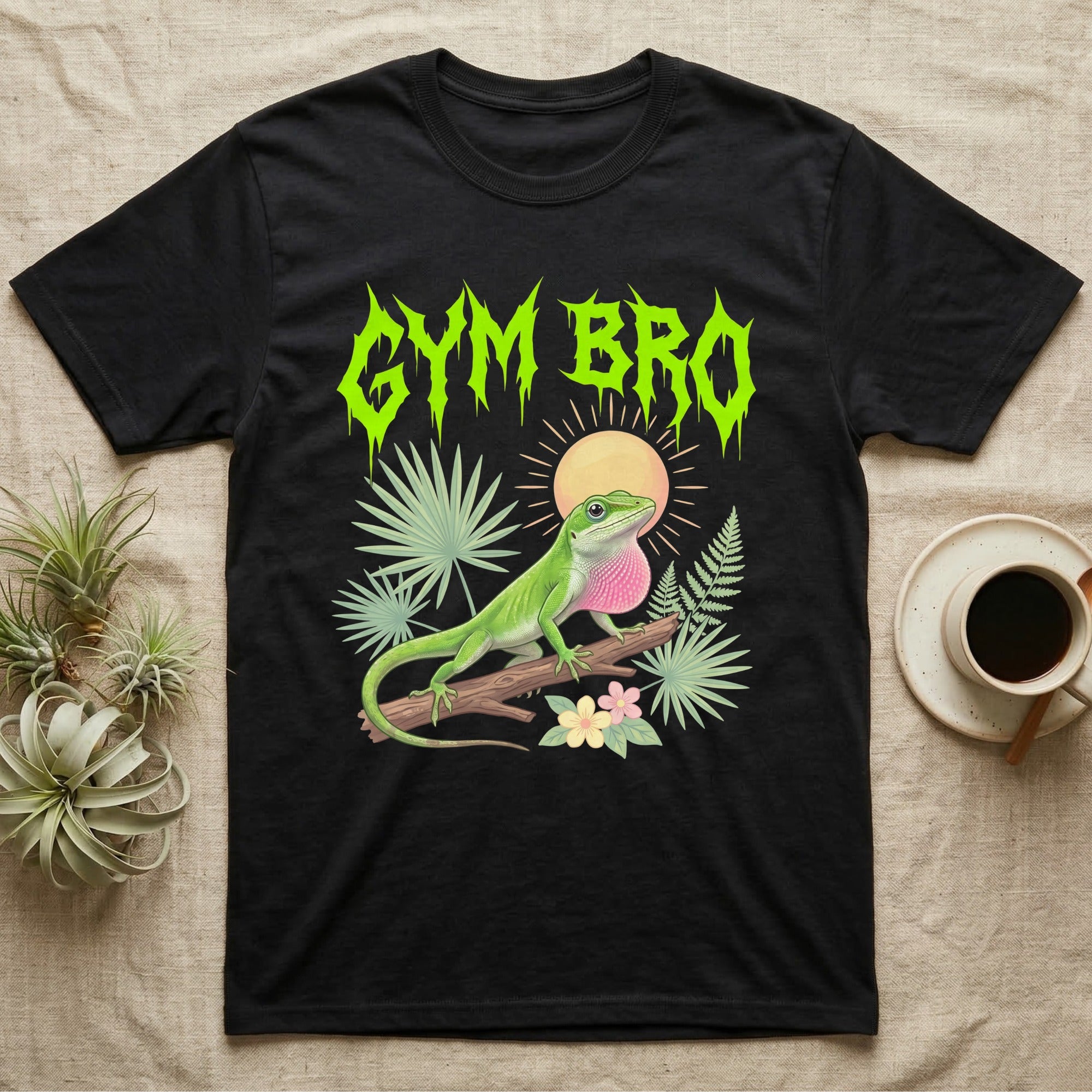 Green Anole Feral T-Shirt in Black — Green anole mid push-up with flared pink dewlap under a jagged neon-lime metal "GYM BRO" wordmark and pastel ferns.