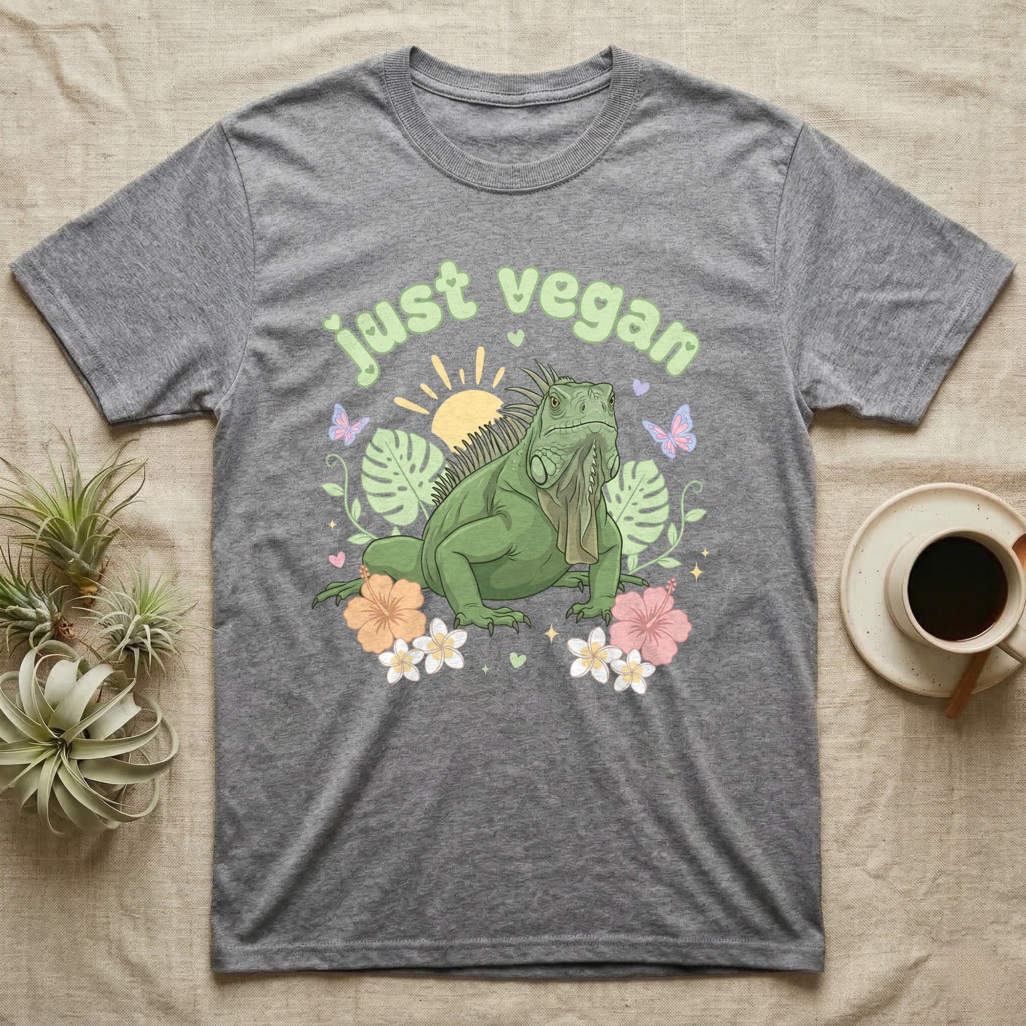 Green Iguana Baby T-Shirt in Sport Grey — Green iguana with spiky crest and dewlap among pastel leaves and flowers under puffy green bubble text "just vegan".