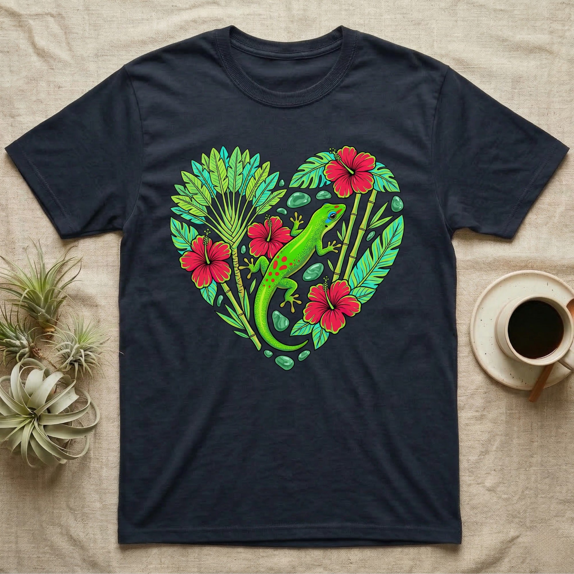Dark t-shirt with heart-shaped tropical leaves, hibiscus flowers, and a green gecko.