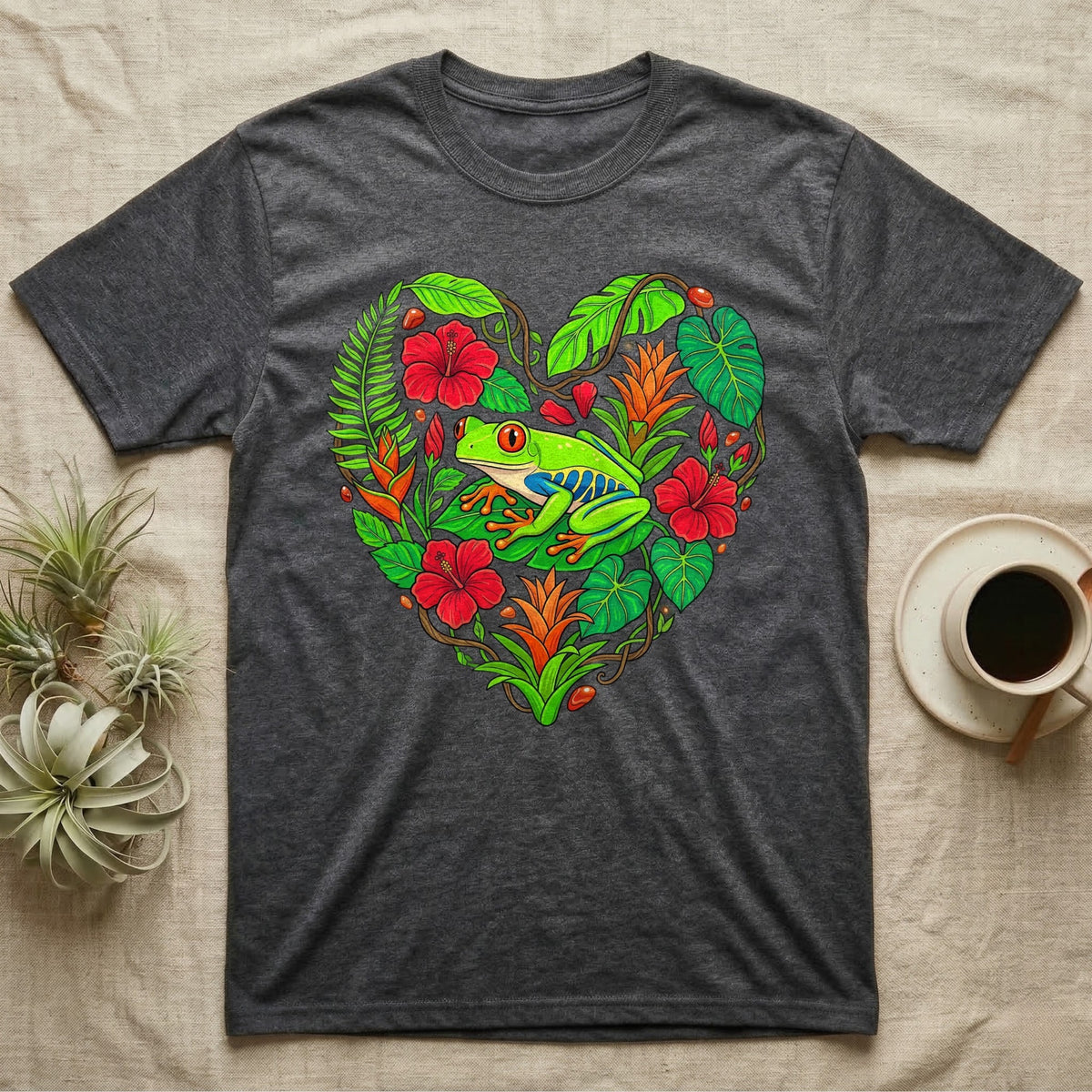 Dark grey t-shirt with a heart-shaped tropical floral design featuring a red-eyed tree frog.