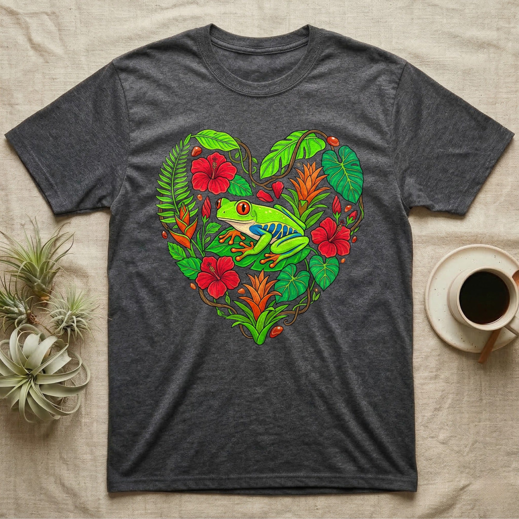 Dark grey t-shirt with a heart-shaped tropical floral design featuring a red-eyed tree frog.