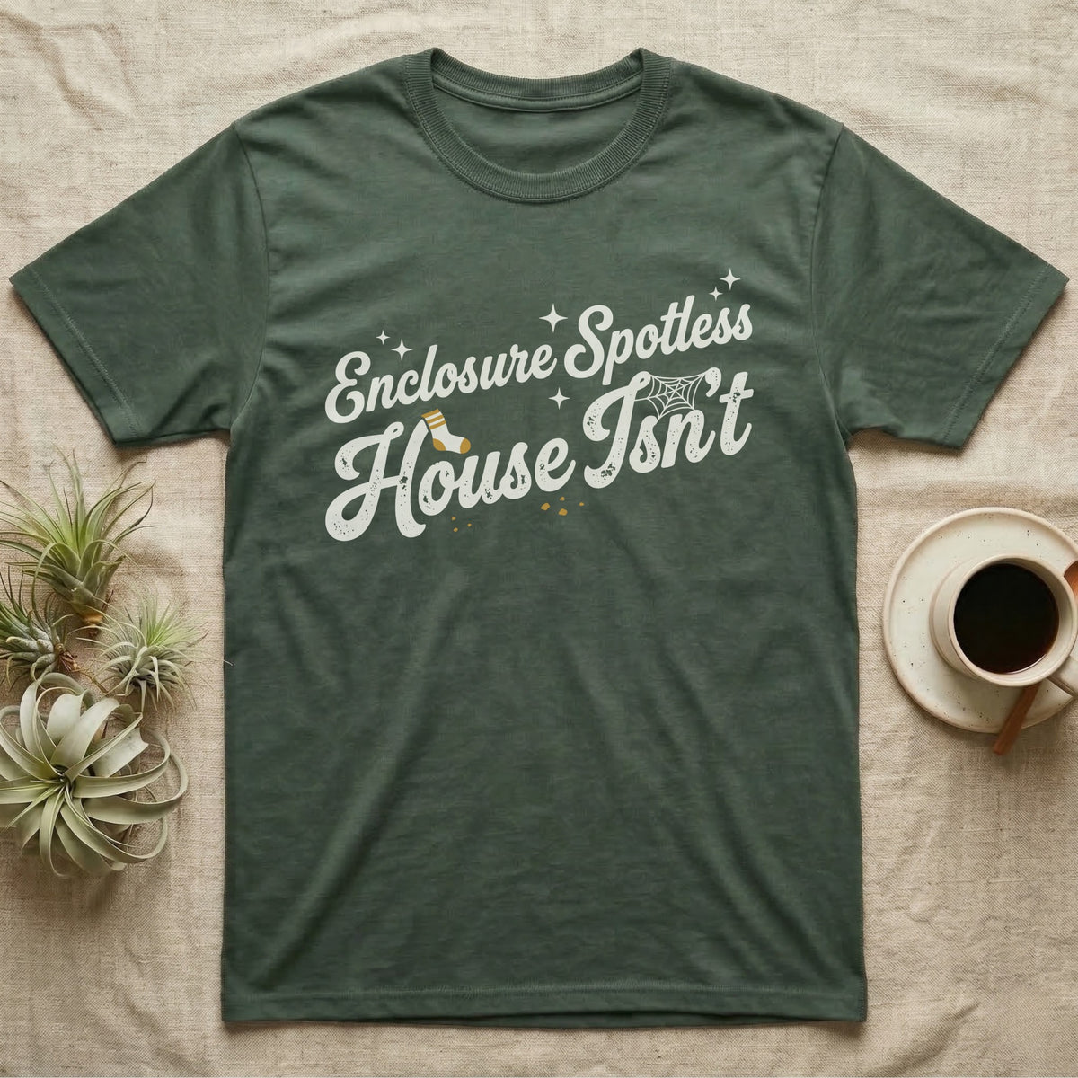 Terrarium Spotless House T-Shirt in Military Green — Retro script reading Enclosure Spotless with sparkles above grubby lettering reading House Isn't with a sock, cobweb and crumbs