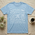 Terrarium Keeper One Tank T-Shirt in Light Blue — White outline illustration of eleven terrarium species — bearded dragon, crested gecko, ball python, axolotl, tortoise, tarantula, isopod, whip spider, chameleon, tree frog and hognose — with pothos and fern leaves, ringed around the script line it started with one tank.
