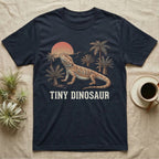 Tiny Dinosaur Bearded Dragon T-Shirt in Navy — Retro natural-history illustration of a bearded dragon in profile in a prehistoric landscape with a distressed "Tiny Dinosaur" caption.
