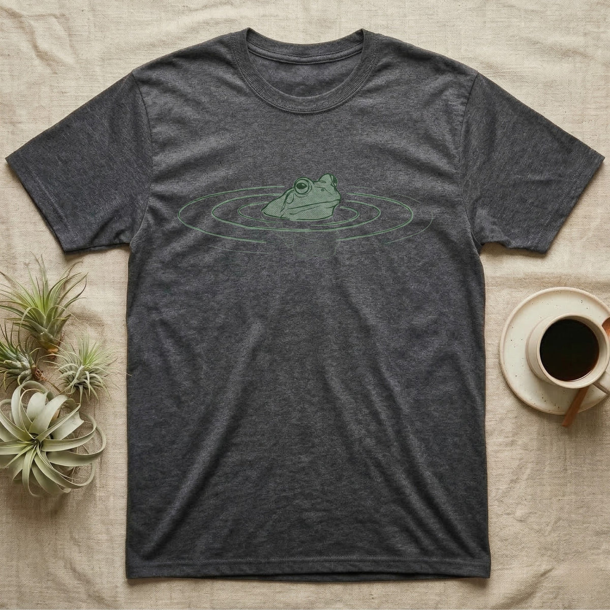 Minimal Swimming Frog T-Shirt in Dark Heather — Minimal single-line illustration of a frog at the waterline with concentric ripple rings and vast negative space.
