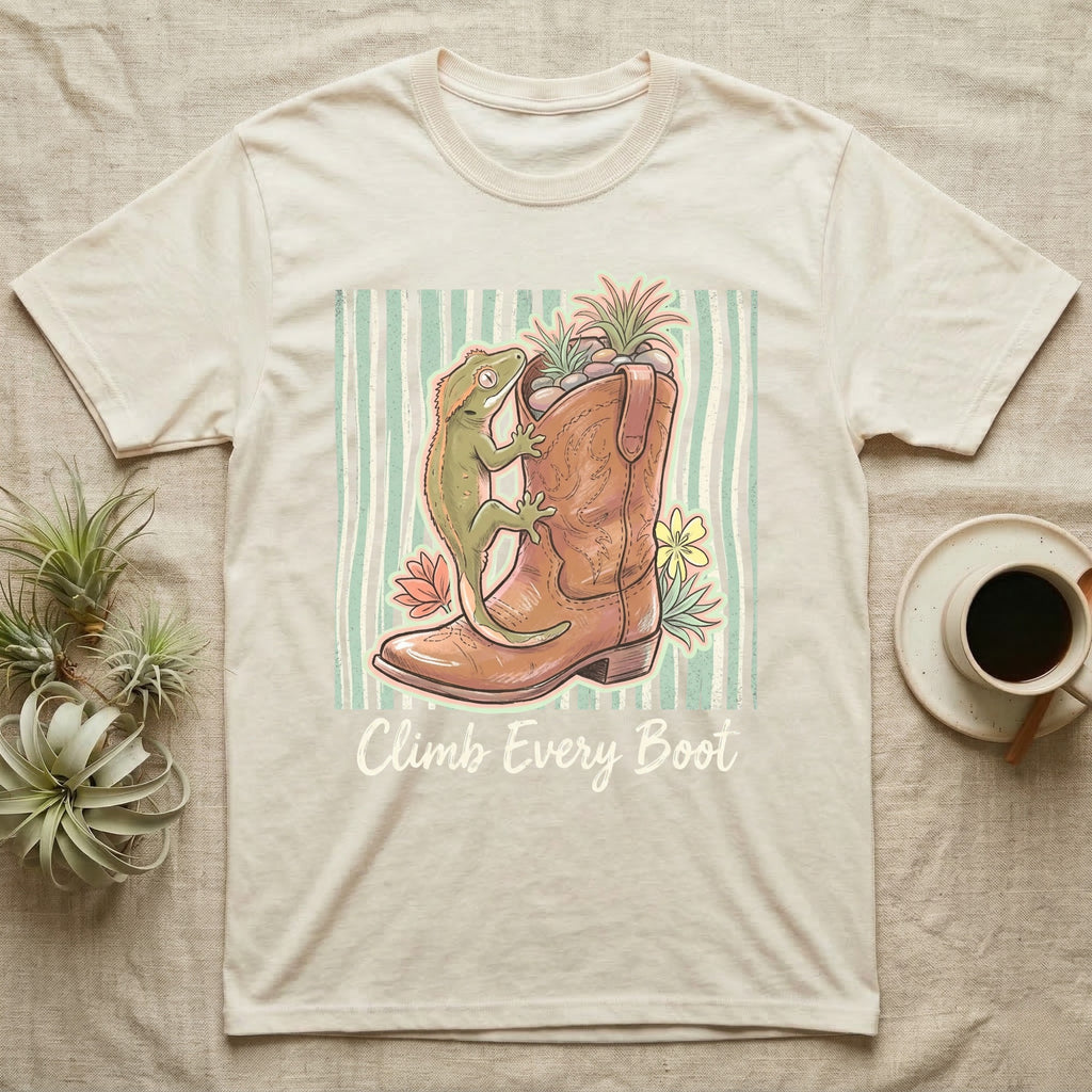 Cream t-shirt with a boot, gecko, plants, and "Climb Every Boot" text.