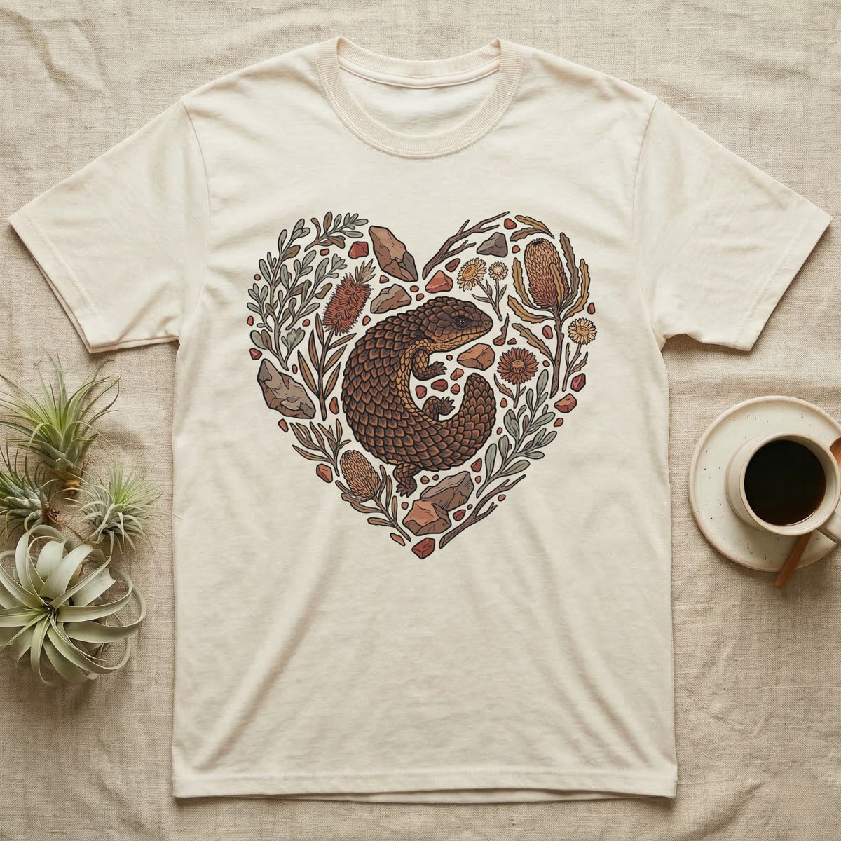 Cream t-shirt with heart-shaped floral and rock design featuring a lizard.