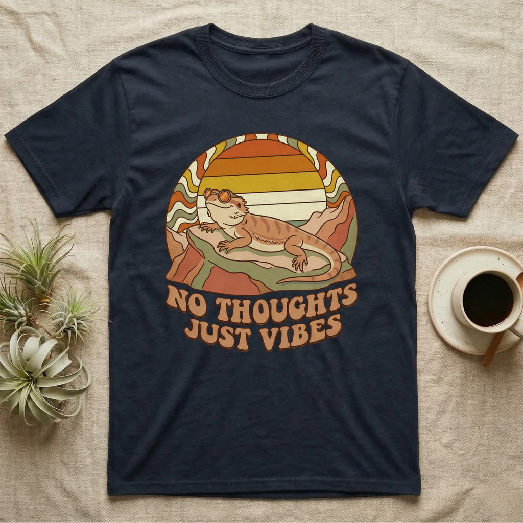 Navy t-shirt with retro sunset, mountains, lizard, and "NO THOUGHTS JUST VIBES" text.