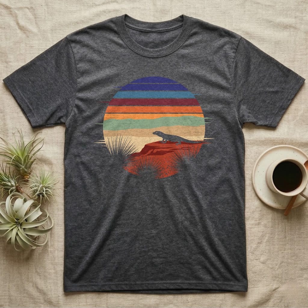 Ackie Monitor Night Window T-Shirt in Dark Heather — Ackie monitor silhouetted on red rock inside a broken circular window of flat stepped desert night colour bands.