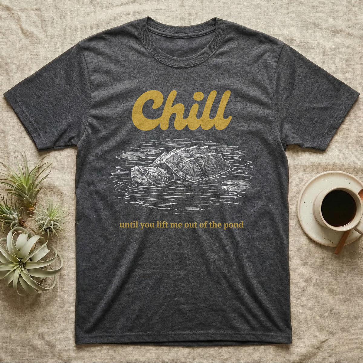 Snapping Turtle Chill T-Shirt in Dark Heather — White-line engraving of a snapping turtle floating among lily pads under the word Chill