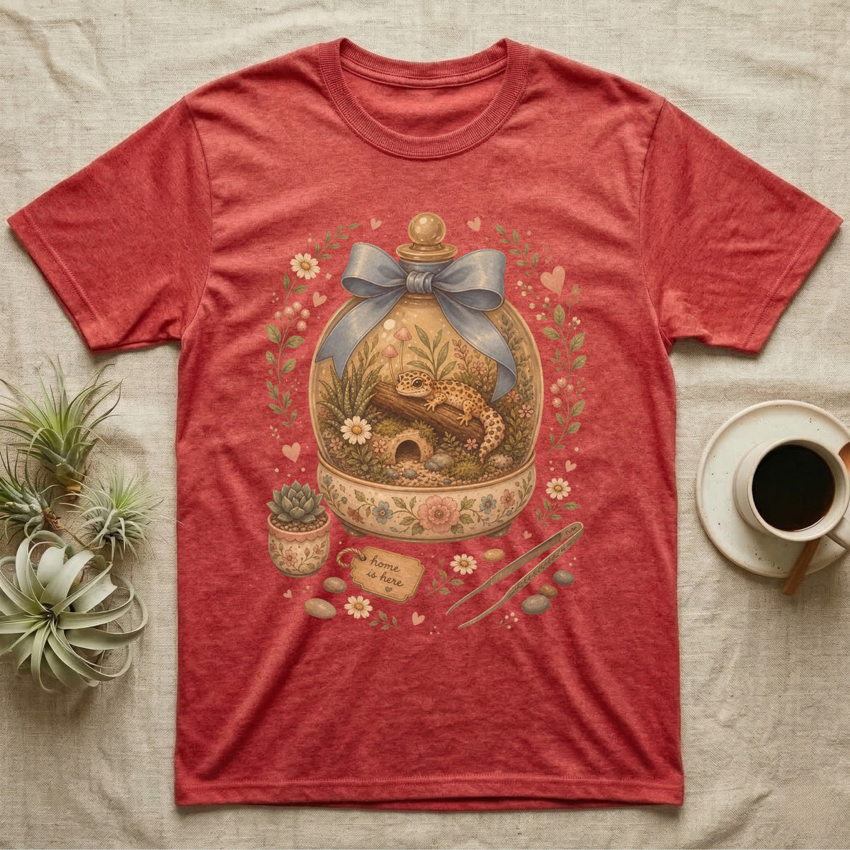 Red t-shirt with a terrarium graphic featuring a gecko and "Home is here" tag.