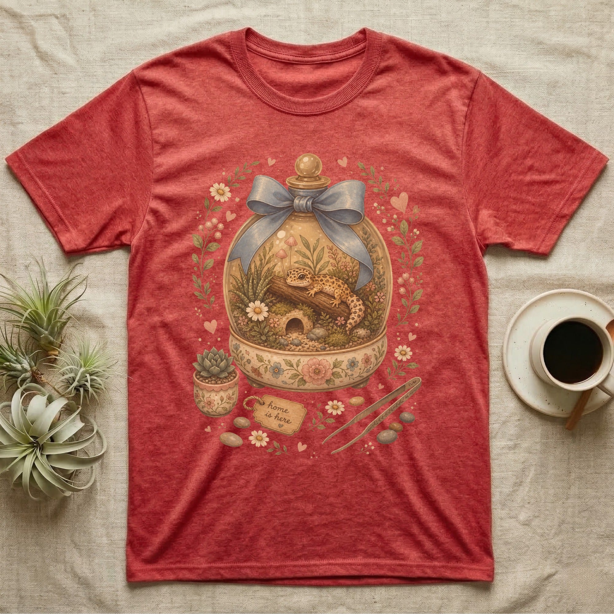 Red t-shirt with a terrarium graphic featuring a gecko and "Home is here" tag.