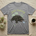 Alligator Snapping Turtle Softie T-Shirt in Sport Grey — Alligator snapping turtle with open mouth and tongue lure under a puffy pastel "just fishing" bubble wordmark.