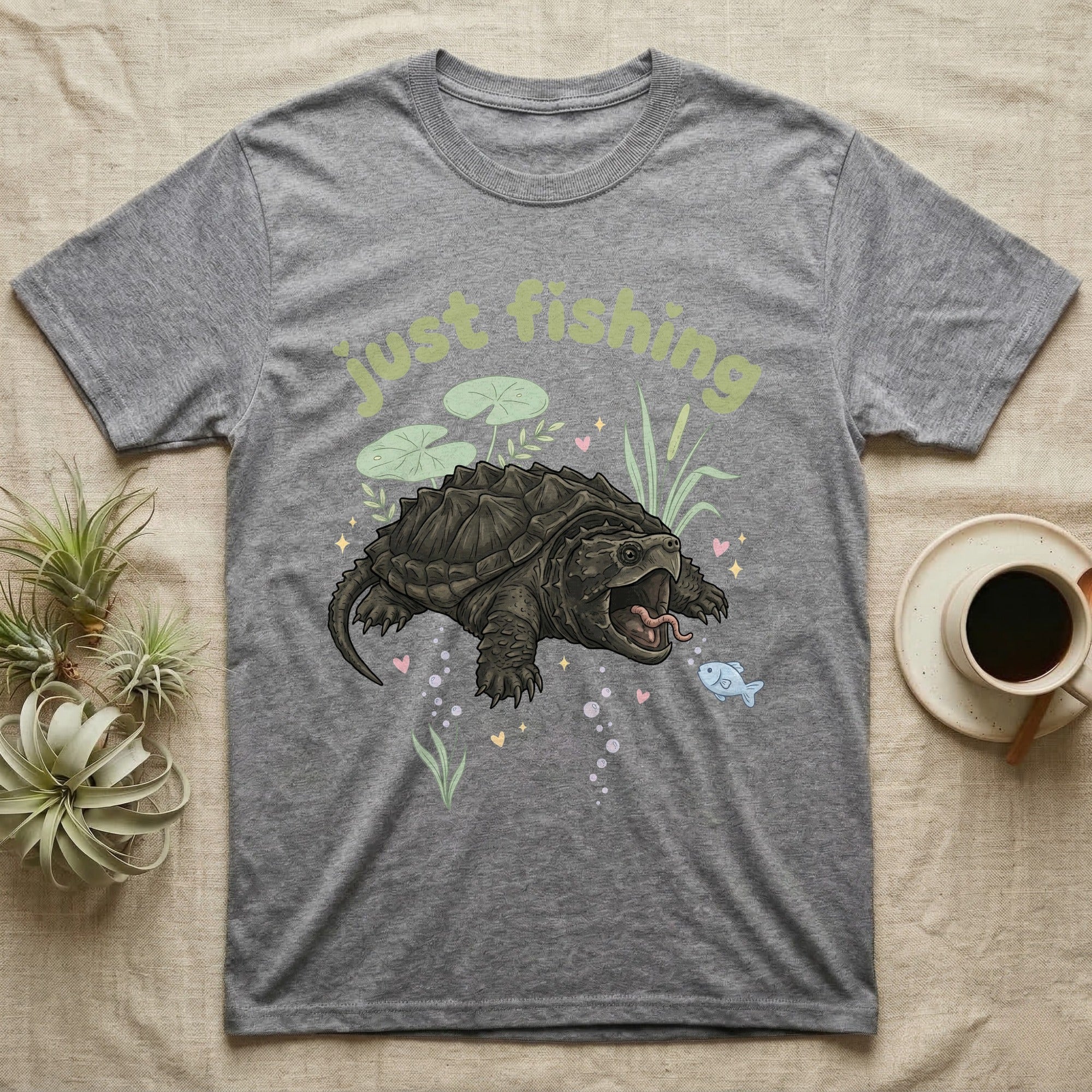 Alligator Snapping Turtle Softie T-Shirt in Sport Grey — Alligator snapping turtle with open mouth and tongue lure under a puffy pastel "just fishing" bubble wordmark.