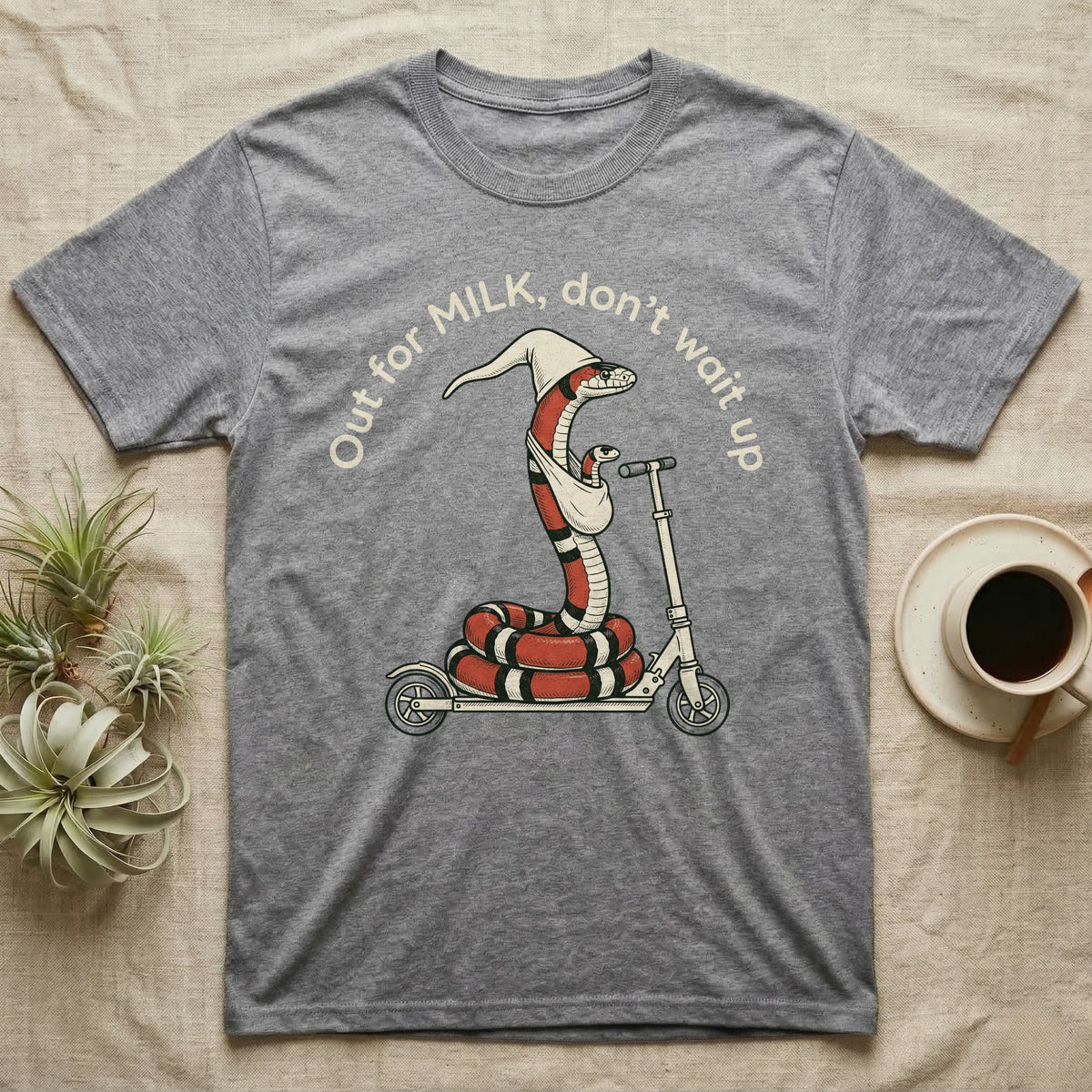 Milk Snake Scooter T-Shirt in Sport Grey — Milk snake in a white cap riding a kick scooter with a baby snake in a sling, under the curved words Out for MILK, don't wait up.