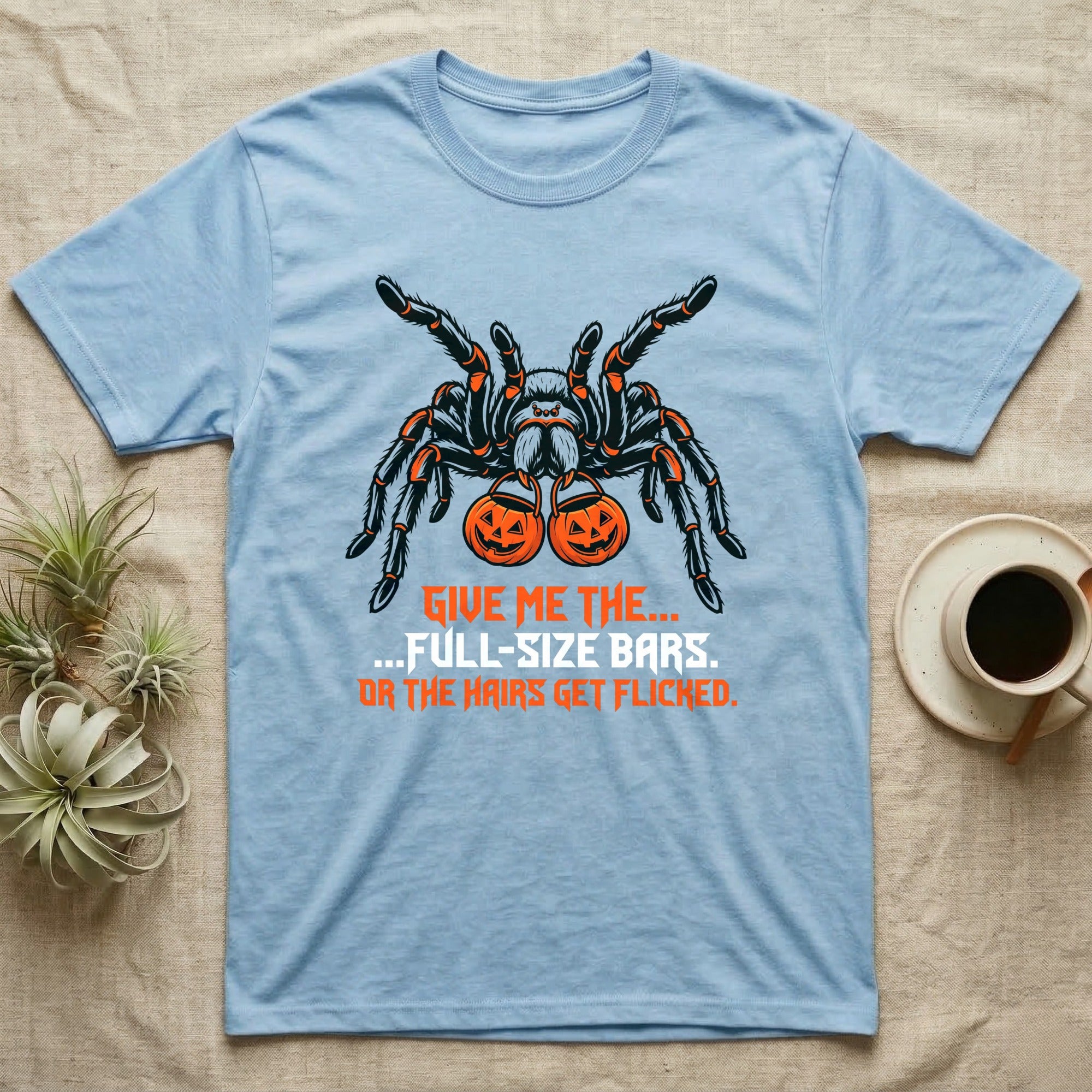 Tarantula Full-Size Bars T-Shirt in Light Blue — Black-and-orange tarantula holding two jack-o'-lantern buckets, "Give Me the Full-Size Bars Or the Hairs Get Flicked."
