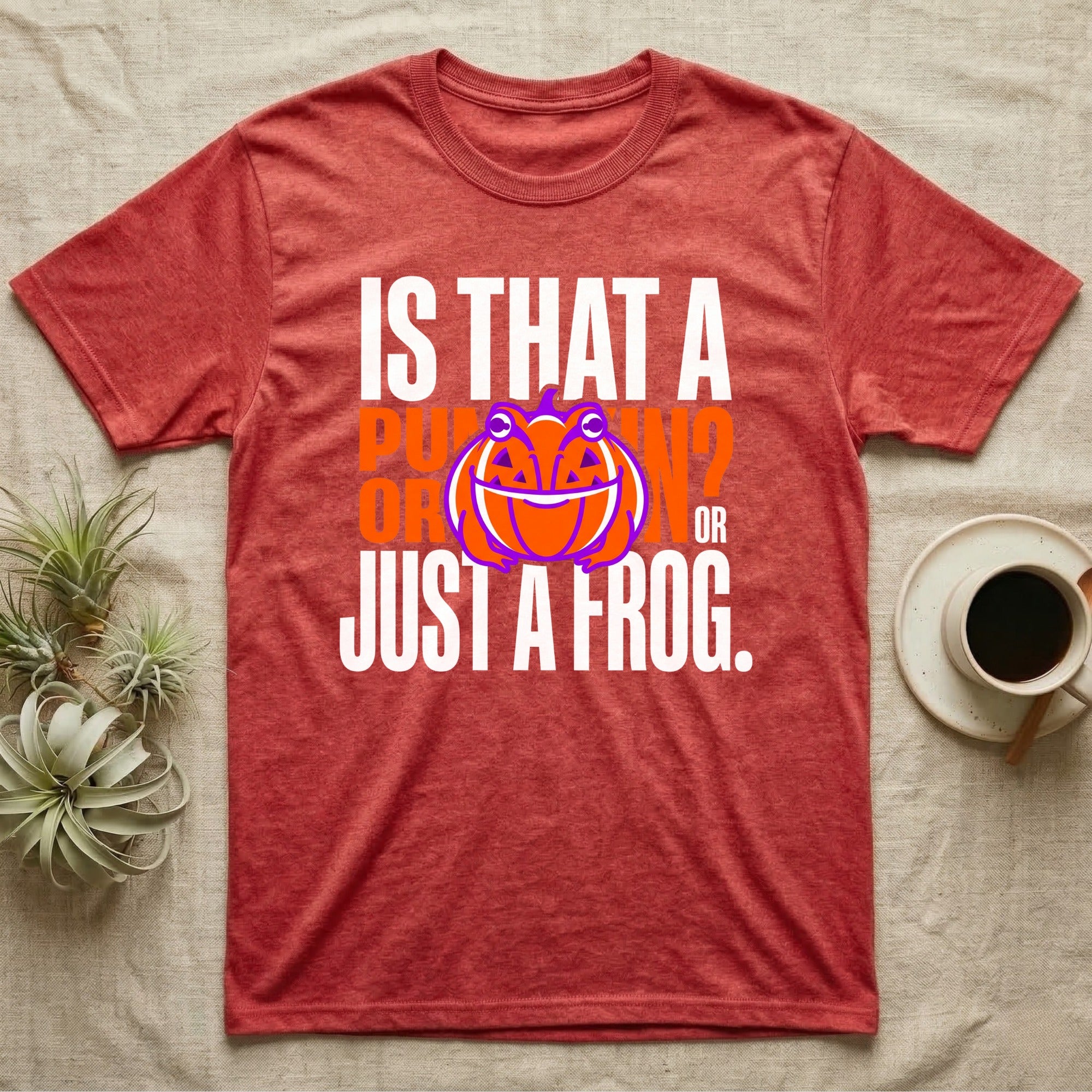 Frog Jack-O'-Lantern Illusion T-Shirt in Heather Red — Typographic graphic of an orange frog doubling as a jack-o'-lantern, "Is That a Pumpkin? Or Just a Frog."