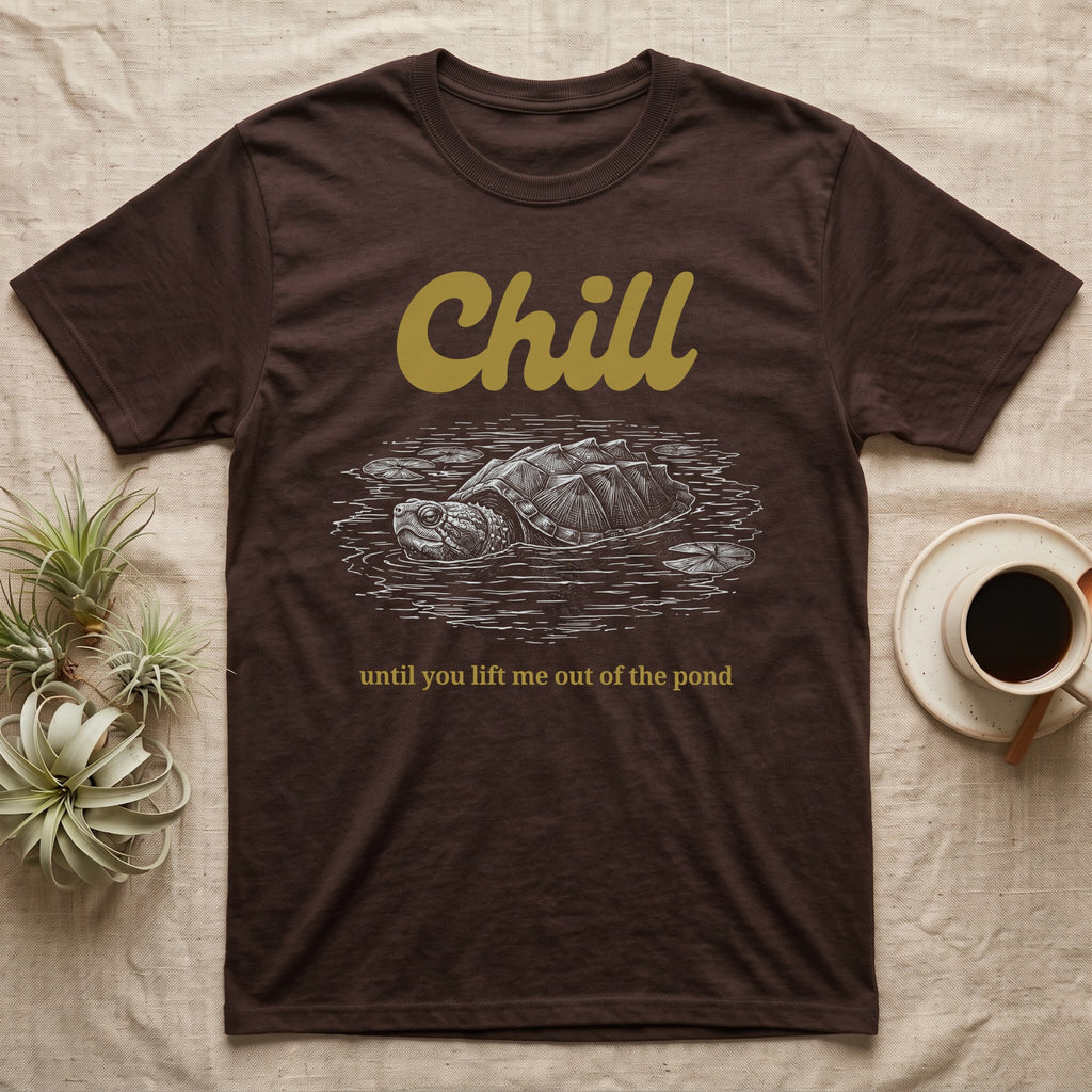 Snapping Turtle Chill T-Shirt in Dark Chocolate — White-line engraving of a snapping turtle floating among lily pads under the word Chill