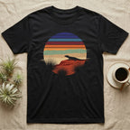 Ackie Monitor Night Window T-Shirt in Black — Ackie monitor silhouetted on red rock inside a broken circular window of flat stepped desert night colour bands.