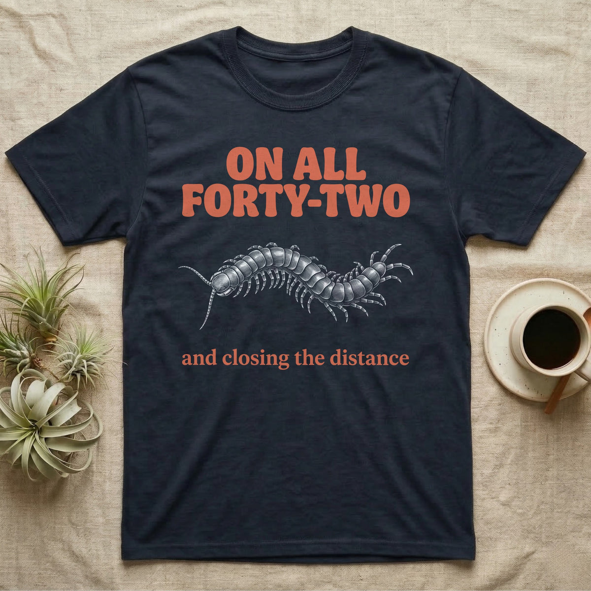 Dark t-shirt with orange text "ON ALL FORTY-TWO" and a centipede graphic.