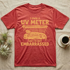 Reptile Keeper UV Meter T-Shirt in Heather Red — Linocut block-print badge of a UVB tube lamp above an empty basking rock, ringed by carved slogan lettering.