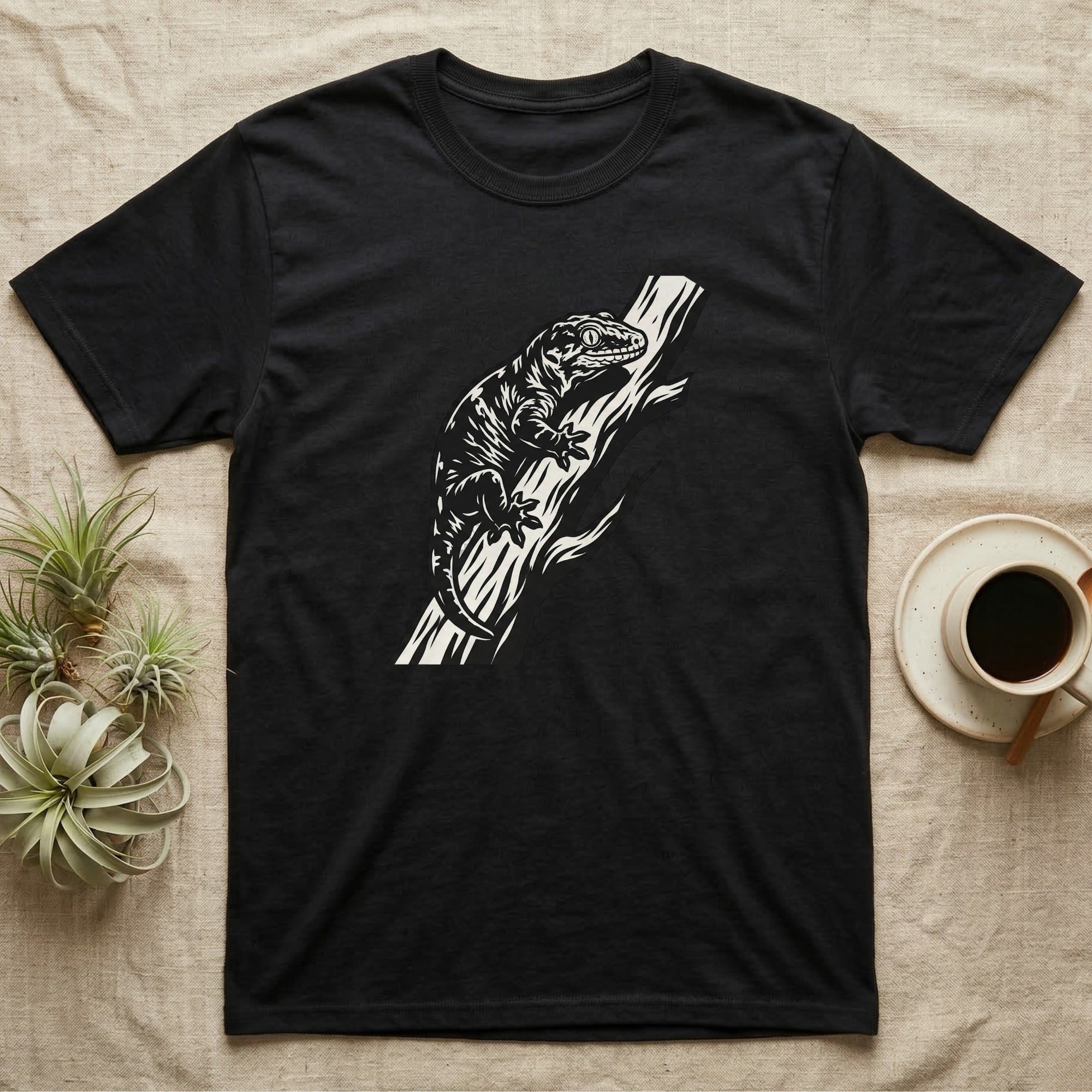 Black t-shirt with a white stylized illustration of a gecko on a branch.