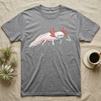 Axolotl Blossom T-Shirt in Sport Grey — Watercolor illustration of a pink leucistic axolotl with feathery gills holding an aquatic blossom sprig, on a dark grey t-shirt.