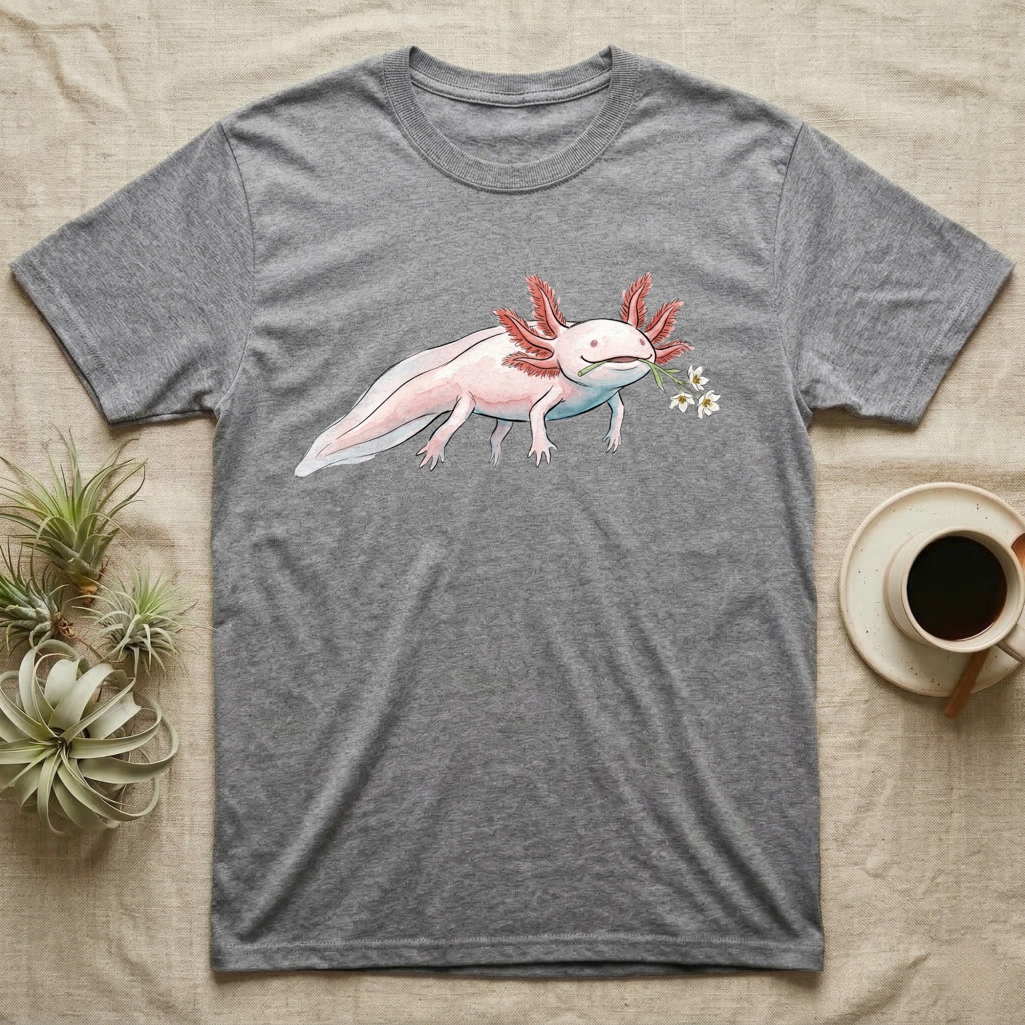 Axolotl Blossom T-Shirt in Sport Grey — Watercolor illustration of a pink leucistic axolotl with feathery gills holding an aquatic blossom sprig, on a dark grey t-shirt.
