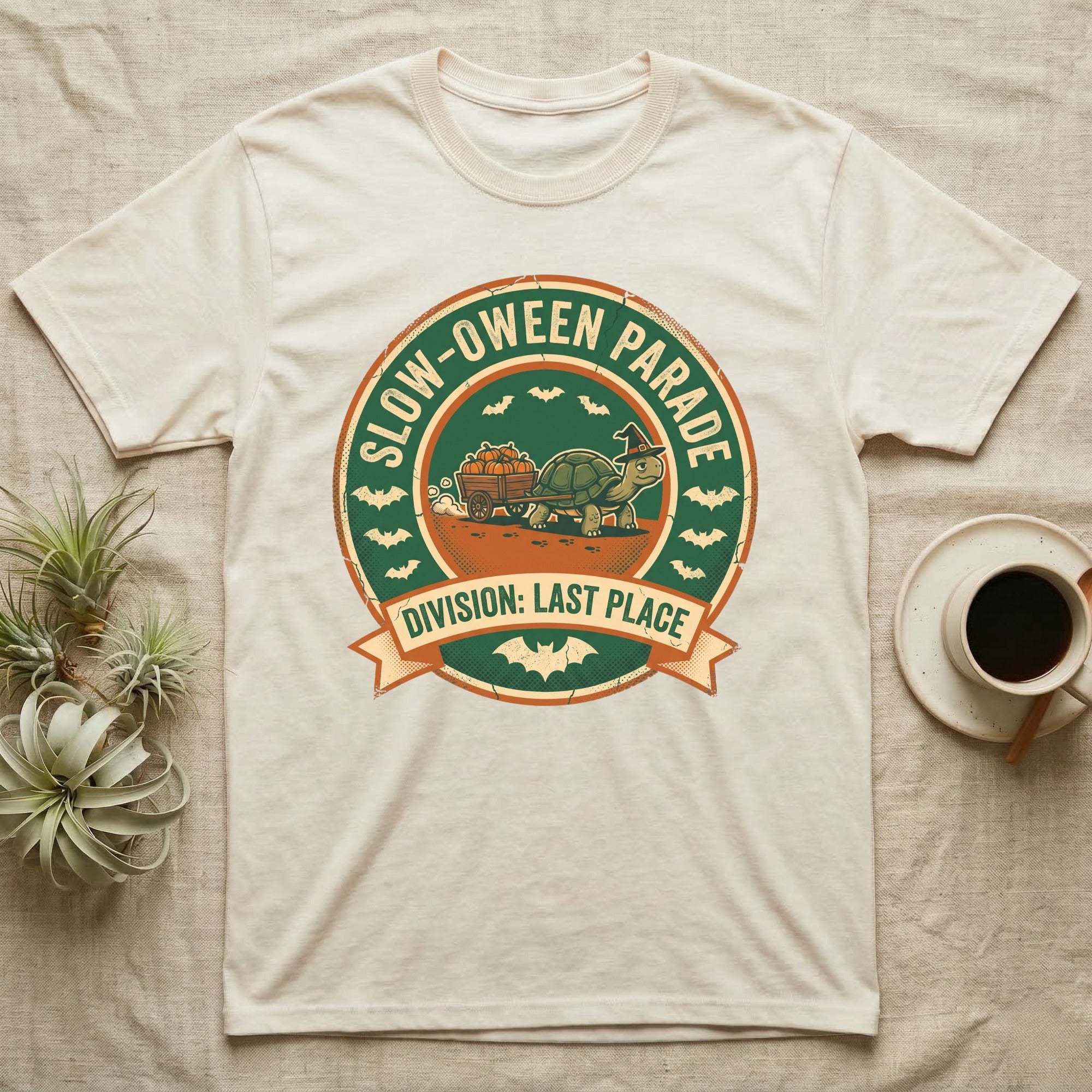 Tortoise Slow-oween Parade T-Shirt in Natural — Distressed badge of a witch-hatted tortoise pulling a pumpkin wagon, "Slow-oween Parade, Division Last Place."