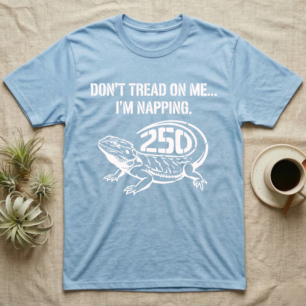 Bearded Dragon Napping T-Shirt in Light Blue — White stencil bearded dragon resting with 250 cut into the tail under text Don't Tread On Me, I'm Napping.
