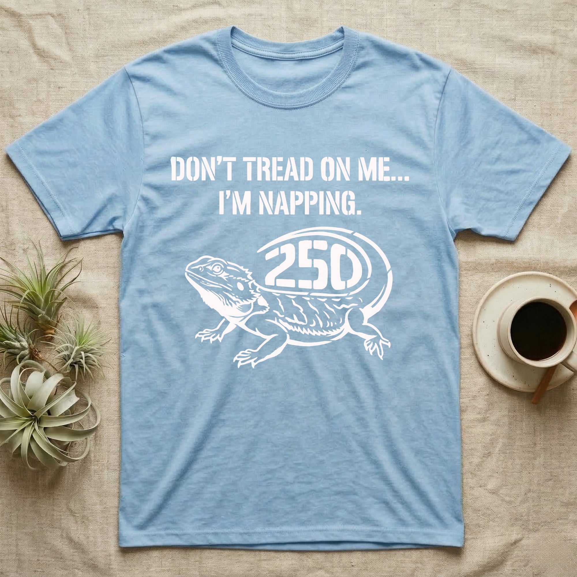 Bearded Dragon Napping T-Shirt in Light Blue — White stencil bearded dragon resting with 250 cut into the tail under text Don't Tread On Me, I'm Napping.